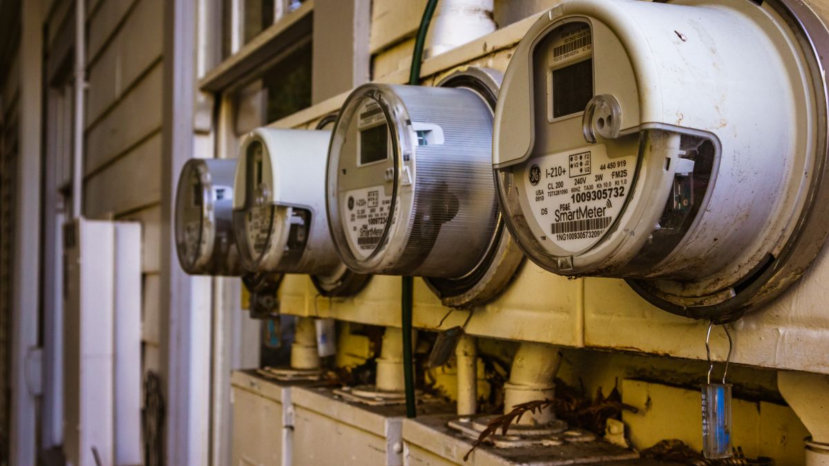 Plusieurs compteurs électriques intelligents installés côte à côte sur le mur extérieur d’une habitation