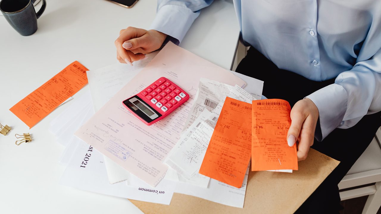 Personne comparant des factures avec une calculatrice